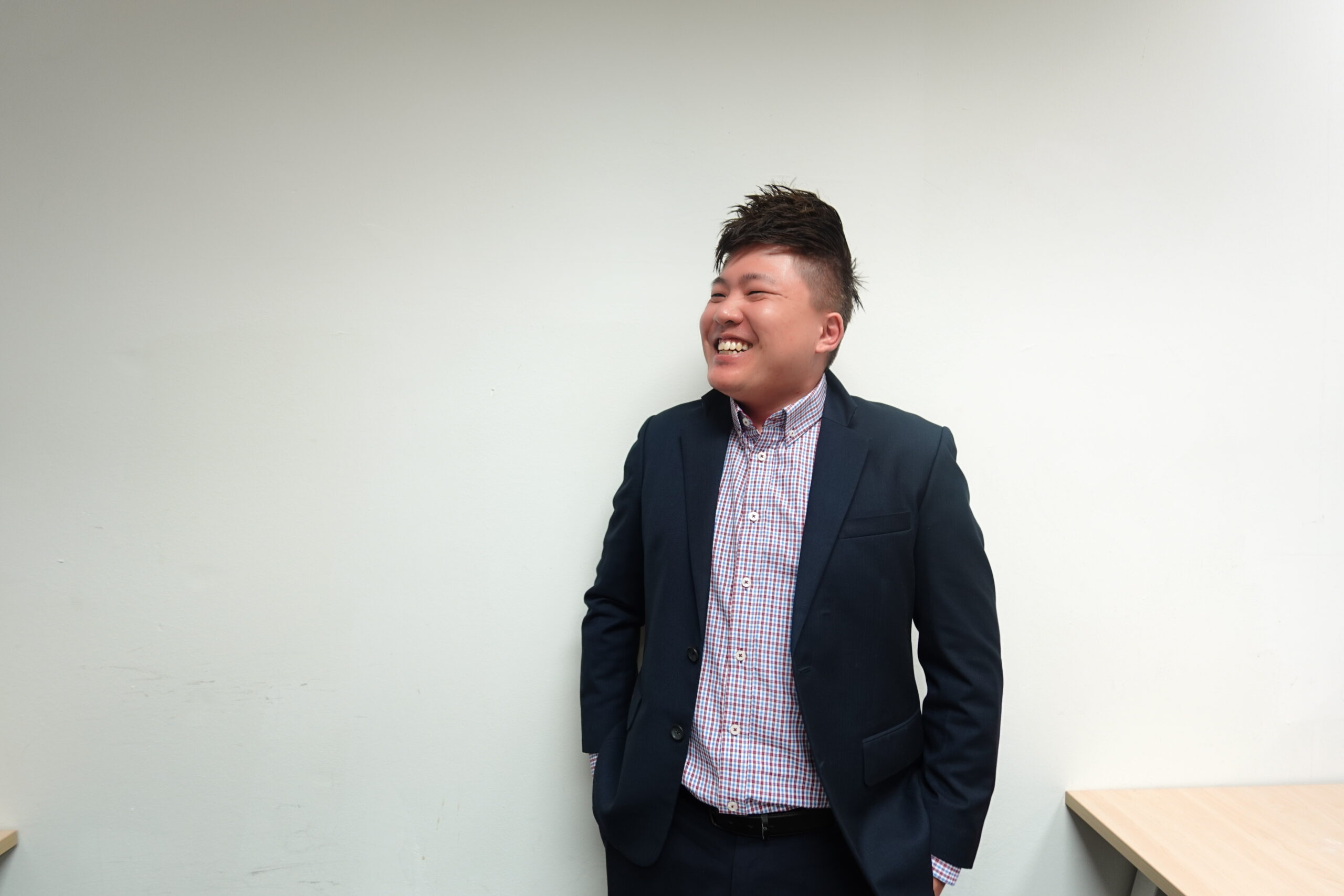 Smiling male leader in a blazer and checked shirt