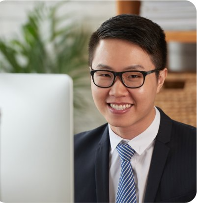 Smiling male professional at computer in formal attire