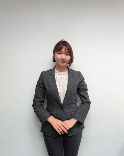 Female business executive in a grey blazer, standing confidently